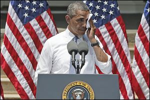 President Obama wipes perspiration from his face as he speaks about climate change  in Washington in June. 