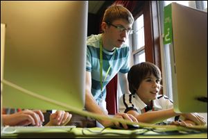 Instructor Thaddeus Owings, left, helps camper Nicholas Sanchez work on creating a video game while at an iD Tech Camp at the Emory University campus, in Atlanta, last week.