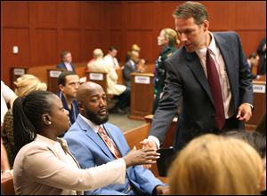 The parents of Trayvon Martin, Sybrina Fulton, left, and Tracy Martin, center, are greeted by assistant state attorney John Guy during the George Zimmerman trial in Seminole circuit court, in Sanford, Fla., Monday.