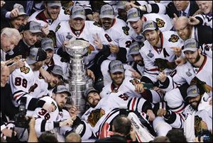 The Chicago Blackhawks pose with the Stanley Cup after beating the Boston Bruins 3-2 in Game 6 of the Stanley Cup Final on Monday in Boston.