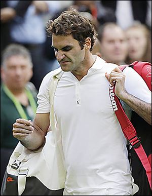 Roger Federer walks off the court after losing to Sergiy Stakhovsky  6-7 (5), 7-6 (5), 7-5, 7-6 (5) in the second round.