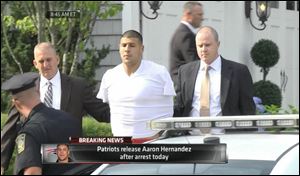 This image from ESPN shows police escorting Aaron Hernandez from his home in handcuffs in Attleboro, Mass., today.