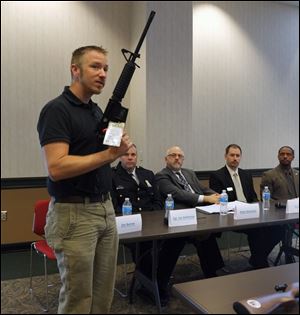 Jim Barnes of Gander Mountain talks about a rifle. Listening are panelists, from left, Sgt. Joe Heffernan, Mark Abramson, C.J. Hoyt, and Romules Durant.