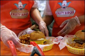 Krusty Burger employees prepare a burger at the Krusty Burger in Universal Orlando.