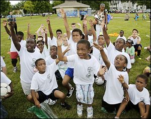 Braylon Ballard, 5, center, and other children get excited while winning prizes during the soccer minicamp at SmithFest.
