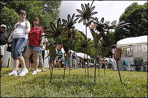 Holly Rising, left, of Temperance and her mom, Robin Moore, of White Lake, Mich., look over steel art. The annual festival con-tinues from 10 a.m. to 4 p.m. today.