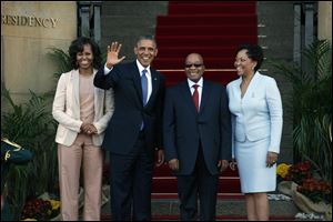 U.S. President Barack Obama flanked by First Lady Michelle Obama, left, waves with South African President Jacob Zuma, second right, and his wife Tobeka Madiba Zuma, right, on the steps of Union Building in Pretoria, South Africa, Saturday June 29, 2013.
