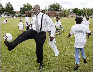 Toledo Mayor Mike Bell plays soccer with children during the soccer minicamp at Smith Park during the city's SmithFest 2013.