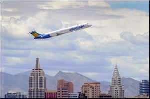 An Allegiant Air jetliner flies over the New York-New York Hotel & Casino after taking off from McCarran International Airport in Las Vegas. The low-cost carrier, based in Las Vegas, relies on additional fees, older aircraft, and lower-than-standard wages.
