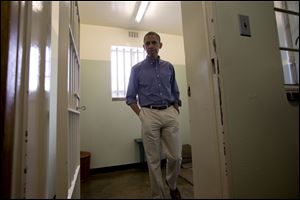 President Obama walks Sunday from Section B, prison cell No. 5, on Robben Island, South Africa. This was former South African president Nelson Mandela's cell, where he spent 18 years of his 27-year prison term on the island locked up by the former apartheid government.