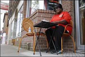 In this Thursday, April 11, 2013 photo, Catherine Jones sits outside her namesake restaurant, in Elmwood Place, Ohio. Jones understands the community's need to install speed cameras to quell speeding, but now she is among many small business owners worried that the cameras have given the village a speed trap stigma. (AP Photo/Al Behrman)