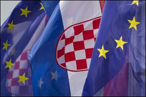 Croatian and the EU flags are seen at an intersection in Zagreb, Croatia, Saturday, June 29, 2013. Croatia is to join the European Union on July 1, 2013. (AP Photo/Darko Bandic)