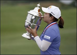 Inbee Park kisses the championship trophy after winning the U.S. Women's Open on Sunday at the Sebonack Golf Club in Southampton, N.Y. Park has won the U.S. Women's Open to make history with titles in the year's first three majors.