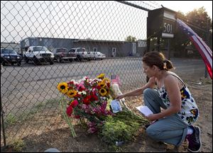 Toby Schultz lays flowers at the gate of the Granite Mountain Hot Shot Crew fire station on Monday.