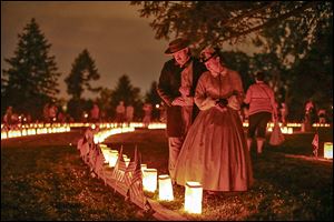 Re-enactors stand near luminaries that mark the graves of Union dead at Soldiers’ National Cemetery in Gettysburg, Pa. On July 1, 1863, Union cavalry slowed down the Confederates’ advance.