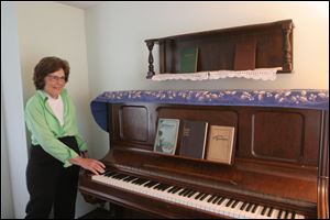 Preservationist Trudy Urbani stands near the historic piano that Ina Duley Ogdon used to write the 1912 hymn 'Brighten the Corner Where You Are' in the very same room of the Century House, Lambertville.