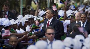 President Obama shakes the hands of a line of women stationed to welcome his arrival, accompanied by Tanzanian President Jakaya Kikwete, right, at State House in Dar es Salaam, Tanzania today.