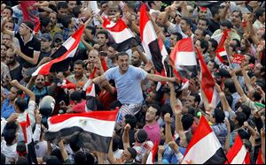 Opponents of Egypt’s Islamist President Mohammed Morsi shout and wave national flags in Liberation Square. Army troops, including commandos, have deployed across much of the Egyptian capital.