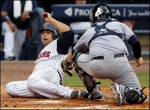Toledo's Matt Tuiasosopo tries to sneak by Columbus Clippers catcher Roberto Perez during the fourth inning.