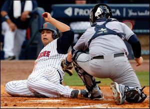 Toledo's designated hitter Matt Tuiasosopo tries to make it home against Columbus Clippers catcher Roberto Perez during the fourth inning.