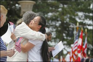 Kim Thi Tran of Lima, Ohio, originally from Vietnam, gets a hug from Nancy Mills of the Daughters of the American Revolution, Fort Industry Chapter, at a naturalization ceremony on South Bass island.