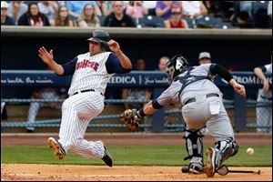 The Mud Hens' Matt Tuiasosopo ducks the tag as he slides home safely in the bottom of the fourth inning, when Toledo scored three times. He has reached base in five of his eight at-bats with Toledo.