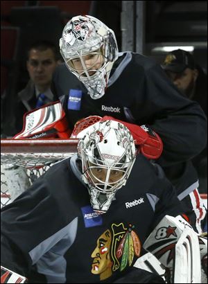 Chicago Blackhawks goalie Corey Crawford, top, watches teammate Ray Emery during an NHL hockey practice Friday, June 21 in Chicago. Emery accepted at $1.65M contract with the Philadelphia Flyers.