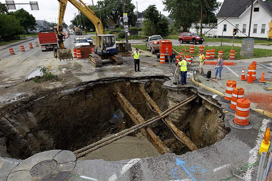 Workers-assess-the-sinkhole-at-Ban