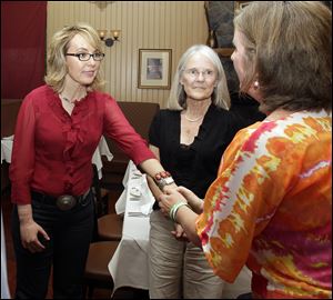 Former Arizona Rep. Gabrielle Giffords greets Jackie Barden, right, mother of a Sandy Hook Elementary School shooting victim Daniel Barden, as local supporter Mary Ann Sosnoff, center, looks on at the Orchard Street Chop Shop in Dover, N.H. 