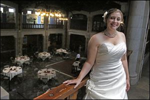 Kristin Rakas, of Bowling Green, stands in the Great Hall of the Toledo Zoo, overlooking the tables set up for her wedding reception.