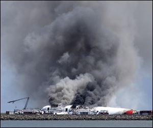 Fire crews work the crash site of Asiana Flight 214 on Saturday at San Francisco International Airport, where two people died.