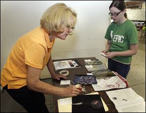 Volunteer Judy Winder of Toledo, left, receives photography entries from Kaylie Awbrey, 13, of Toledo, who is entering the contest for the first time. 