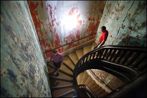 Ehab Jabri of Sylvania, left, and Basem Kareem of Toledo walk down the staircase of the former St. James Hotel. The two purchased the property this year with plans to restore the building.