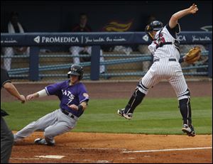 Louisville's Jason Donald scores when Toledo catcher Bryan Holaday is forced off the plate by a high throw.