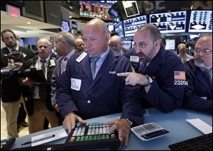 Specialists Michael O'Connor, Peter Giacchi, and Douglas Johnson, foreground left to right, work at the post that handles Sprint on the floor of the New York Stock Exchange today.