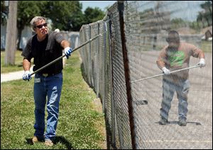 Dave Morton, left, and Brian Goodman, who drive buses for a Kentucky school district, have taken temporary jobs at a high school to earn a little extra money during the summer. 