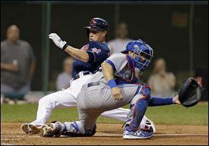 Cleveland Indians' Asdrubal Cabrera slides past Toronto Blue Jays catcher J.P. Arencibia to score on a single by Nick Swisher in the fourth inning.