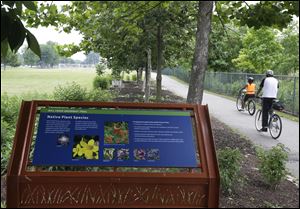 Two bicyclists ride along the Mill Creek Greenway which is being revitalized by the city of Cincinnati.