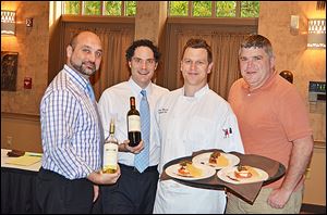 From left, Christopher Knapik and Kevin Boehm of Berman Wines with Chef Sam Misuira and Toledo Zoo executive director Jeff Sailer at the zoo's preview party food tasting for the upcoming FEAST with the beasts.