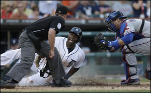 Umpire Quinn Wolcott, left, looks on as Detroit Tigers' Torii Hunter, center, scores under the tag of Texas Rangers catcher A.J. Pierzynski on Tigers' Victor Martinez's double to left field during the second inning Friday.