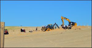 Michigan City firefighters, police, and first responders dig through a sand dune at Mount Baldy near Michigan City, Ind., while searching for a missing 6-year-old-boy who fell into a hole Friday.