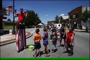 Cincinnati resident Kevin Brandenburg stands on stilts and makes balloons for children.