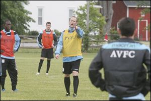 Sylvania-based Pacesetter soccer club coach Ryan Creech, center, instructs his team during May practice.