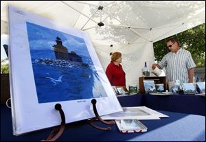 Local artist Gail Wonnell, left, from Sylvania, helps customer Dave Haber, right, from Medina, Ohio, with her art pieces.