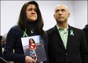 Jennifer Hensel, holding a portrait of her daughter, Sandy Hook School shooting victim Avielle Rose Richman, stands with her husband Jeremy Richman at a news conference at Edmond Town Hall in Newtown, Conn.