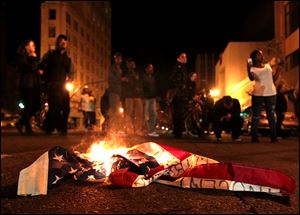 A flag burns during a protest after George Zimmerman was found not guilty, early Sunday in Oakland, Calif. Protesters angered by the acquittal Zimmerman held largely peaceful demonstrations in three California cities, but broke windows and started small street fires Oakland, police said. 