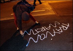 A woman spray paints during a protest in Oakland after George Zimmerman was found not guilty in the 2012 shooting death of teenager Trayvon Martin.