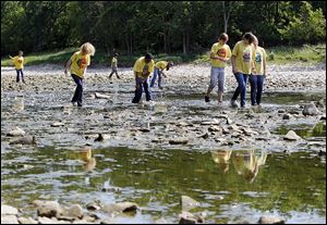 Volunteers from Toledo ZooTeens, in conjunction with Partners for Clean Streams, search the Maumee River last year to remove old lures that are made of lead.