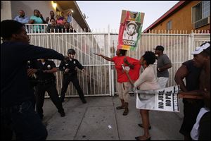 Protesters confront Los Angles police officers during a demonstration in reaction to the acquittal of neighborhood watch volunteer George Zimmerman.