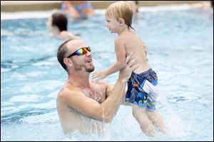 Josh Monaghan catches his son Isaiah, 2, after tossing him in the air at Maumee's Rolf Park Pool.